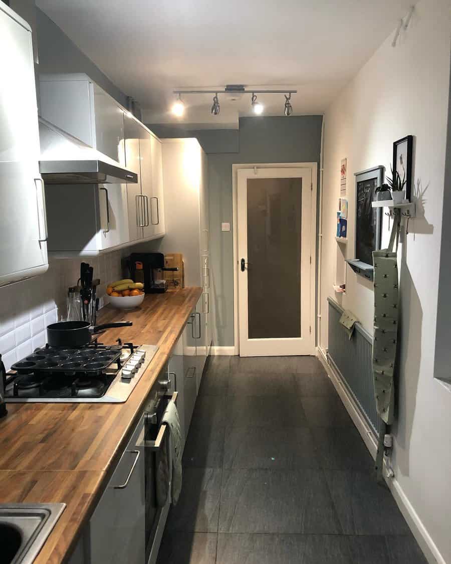 Narrow kitchen with wooden worktops and grey floor