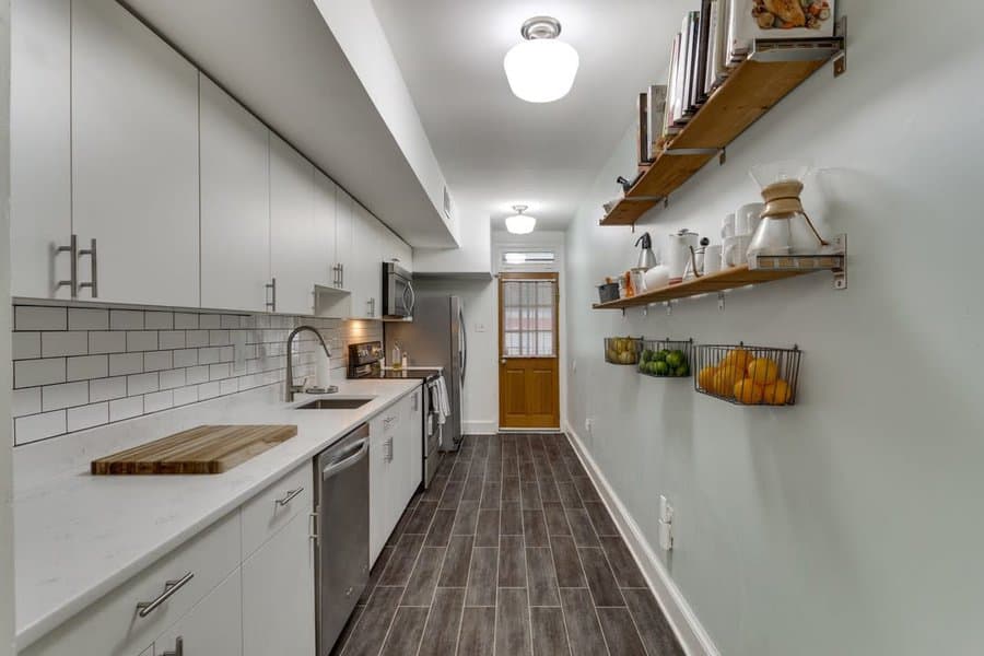 Streamlined galley kitchen with white cabinets and subway tiles