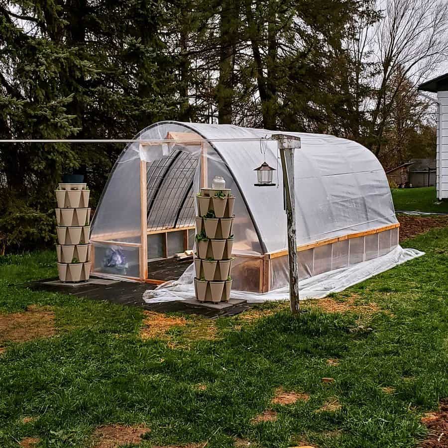 Backyard hoop greenhouse with vertical planters and lantern