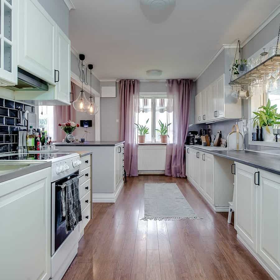 Airy kitchen with white units and lavender curtains