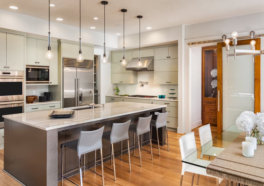 Well lit kitchen with globe pendants and wood details