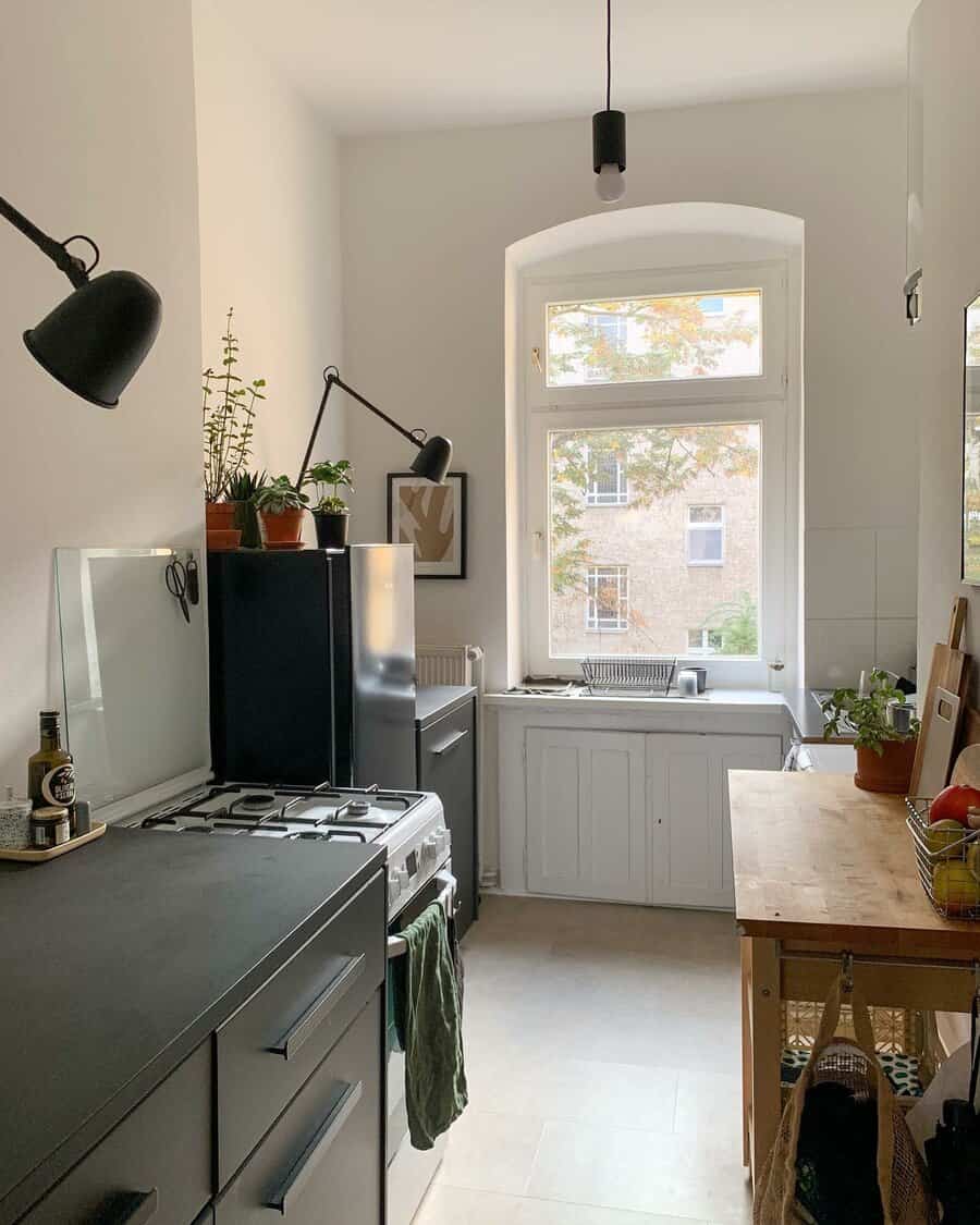 Bright kitchen with arched window and dark cabinets