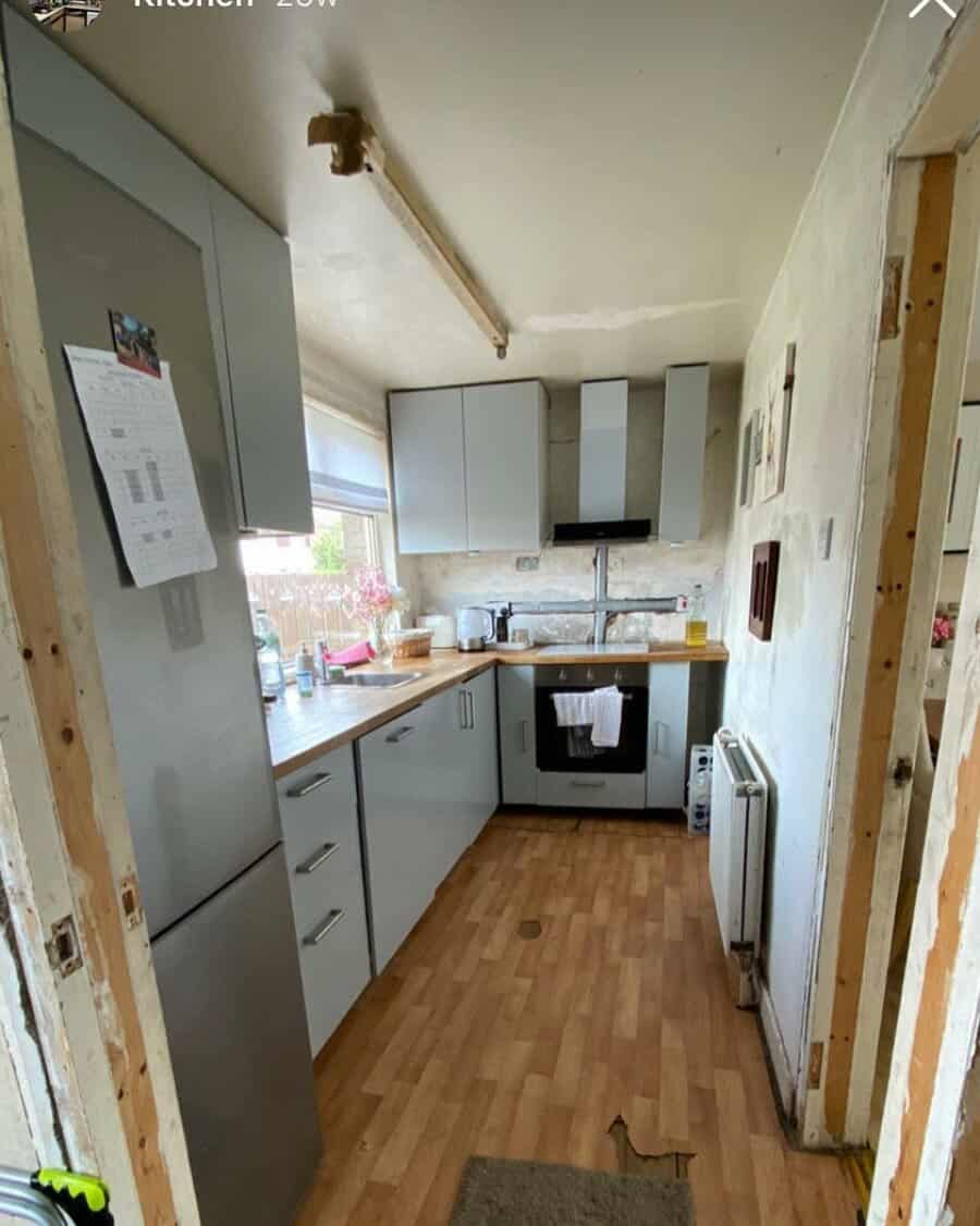 Narrow kitchen with white cabinets and wooden countertop