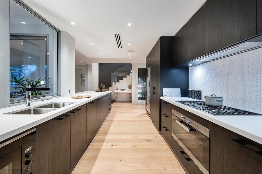 Large modern kitchen with a wooden floor and black cabinets