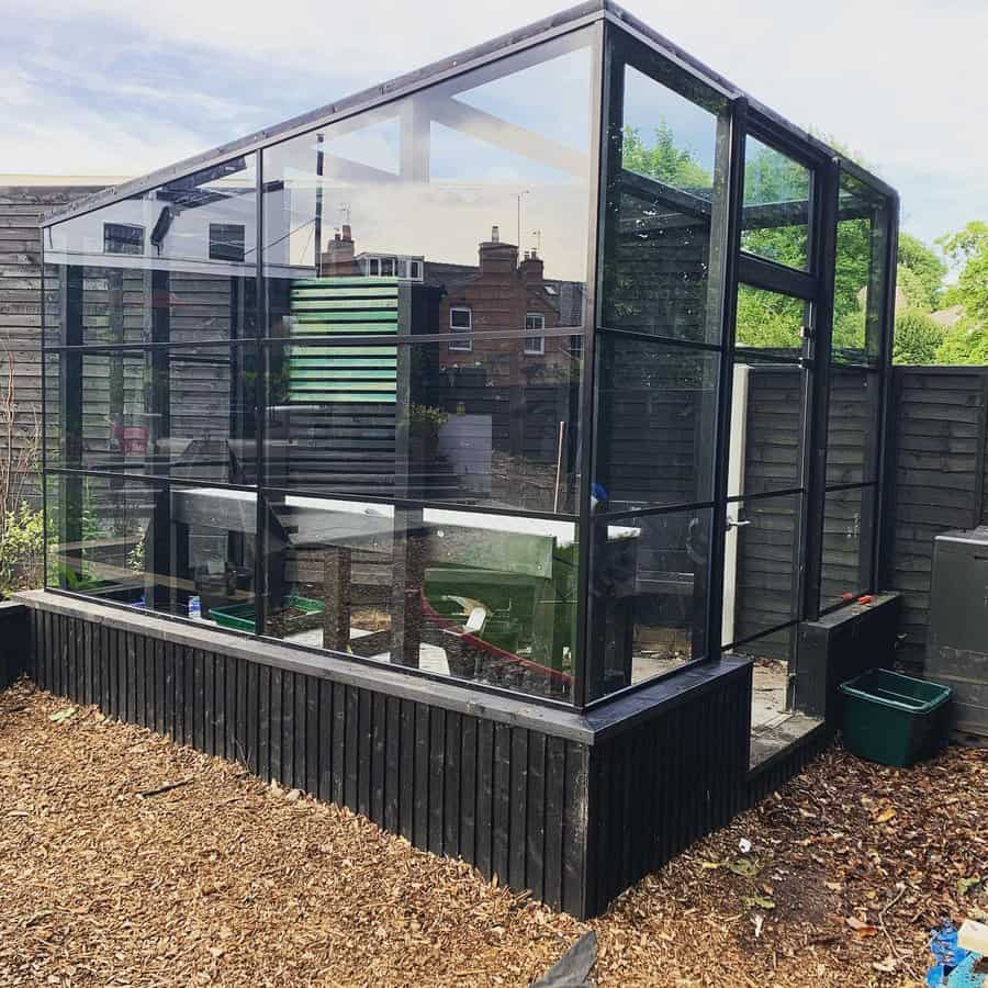 Metal greenhouse in a rustic garden setting