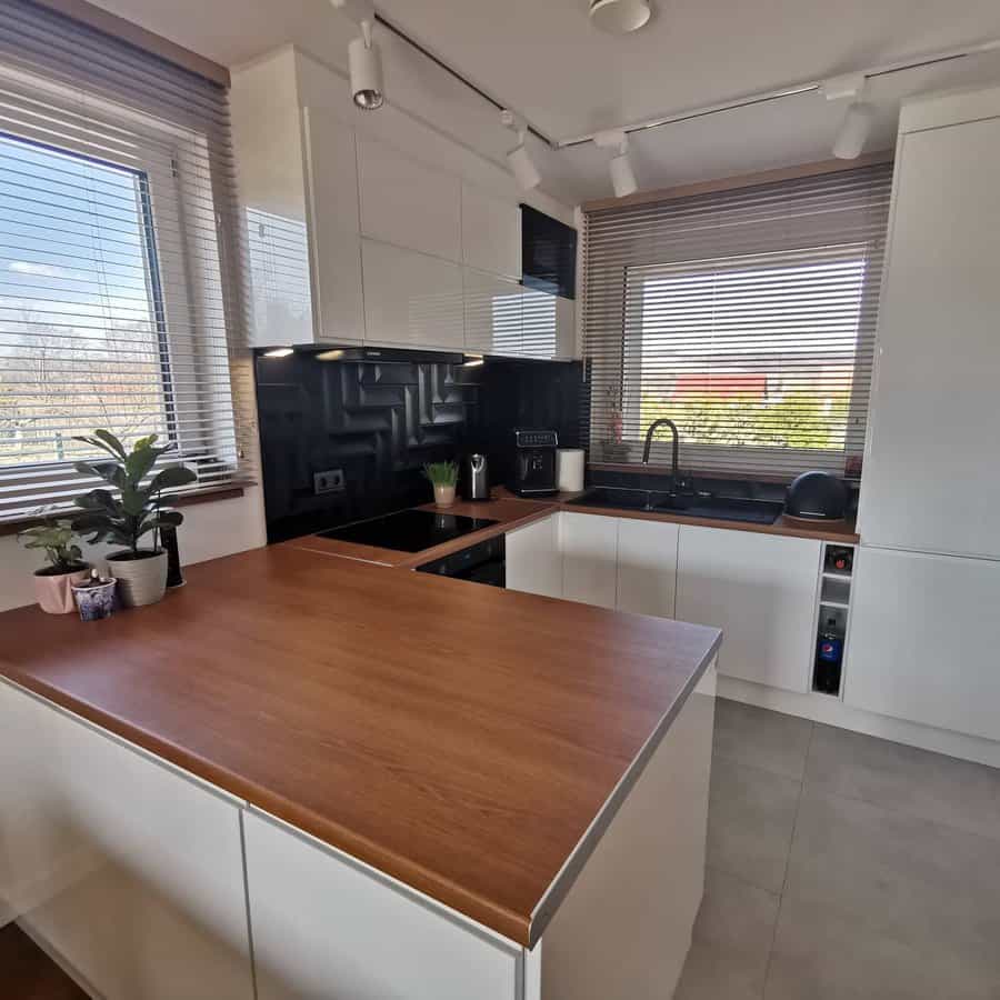 Modern kitchen with white cabinets and blinds