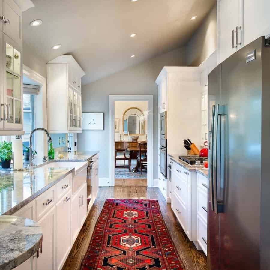 Bright kitchen with white cabinets and a decorative rug