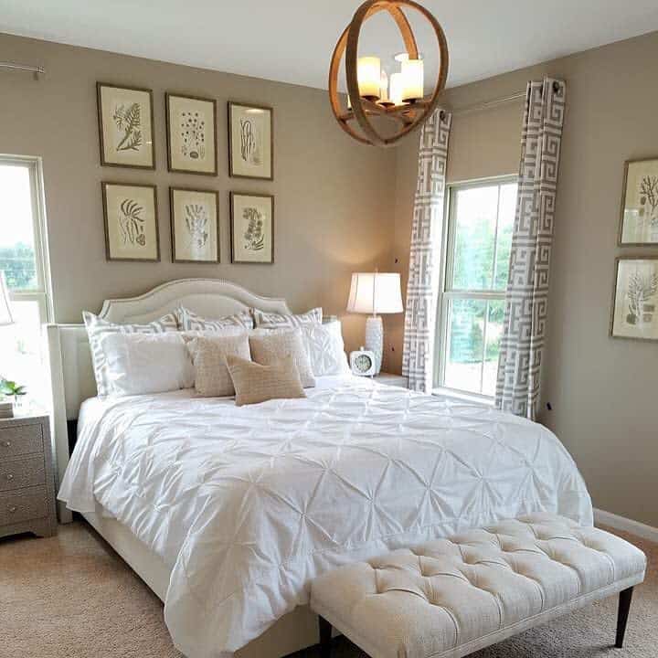 Neutral bedroom with botanical art and a modern circular light fixture