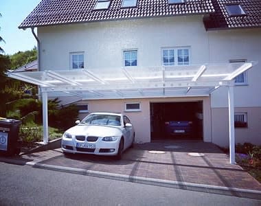 Car under a transparent carport in front of a garage