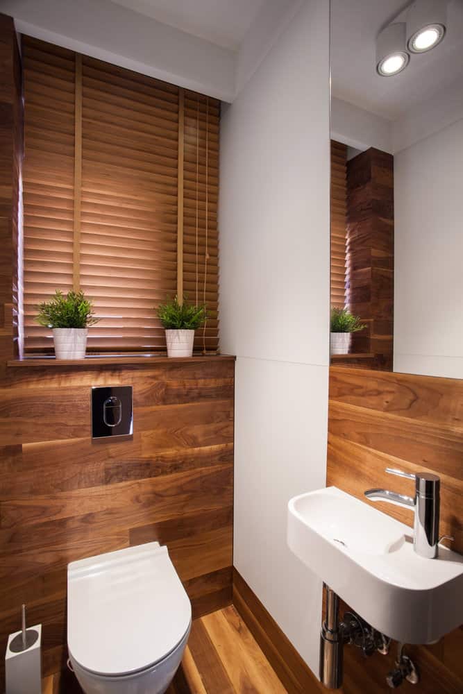 small bathroom with wood walls and flooring