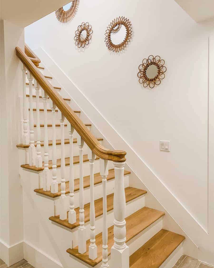 Wooden stairs and white walls adorned with mirrors