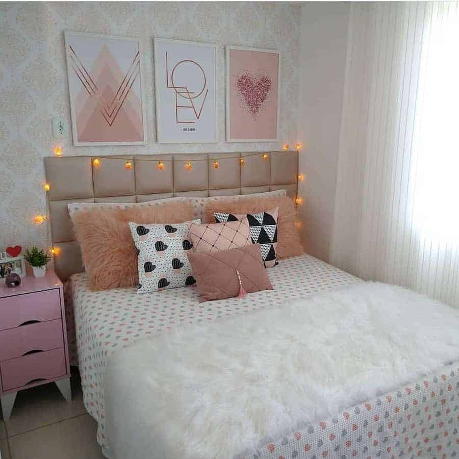 Cozy pink bedroom with art above tufted headboard