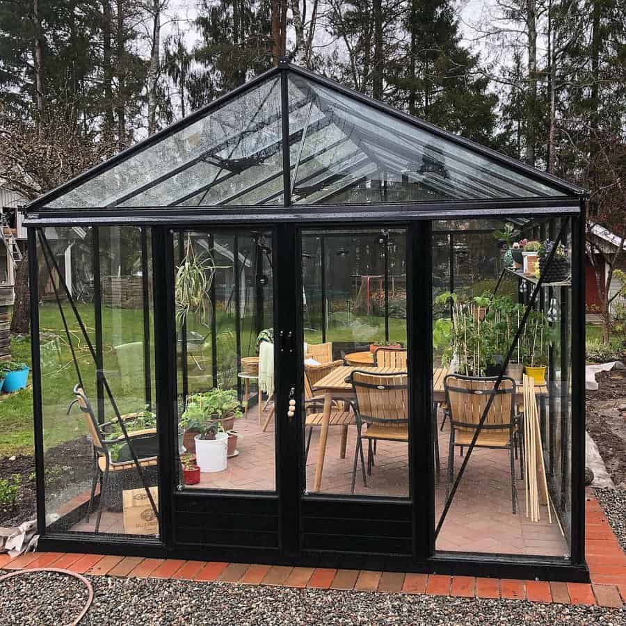 Black greenhouse with patio and table