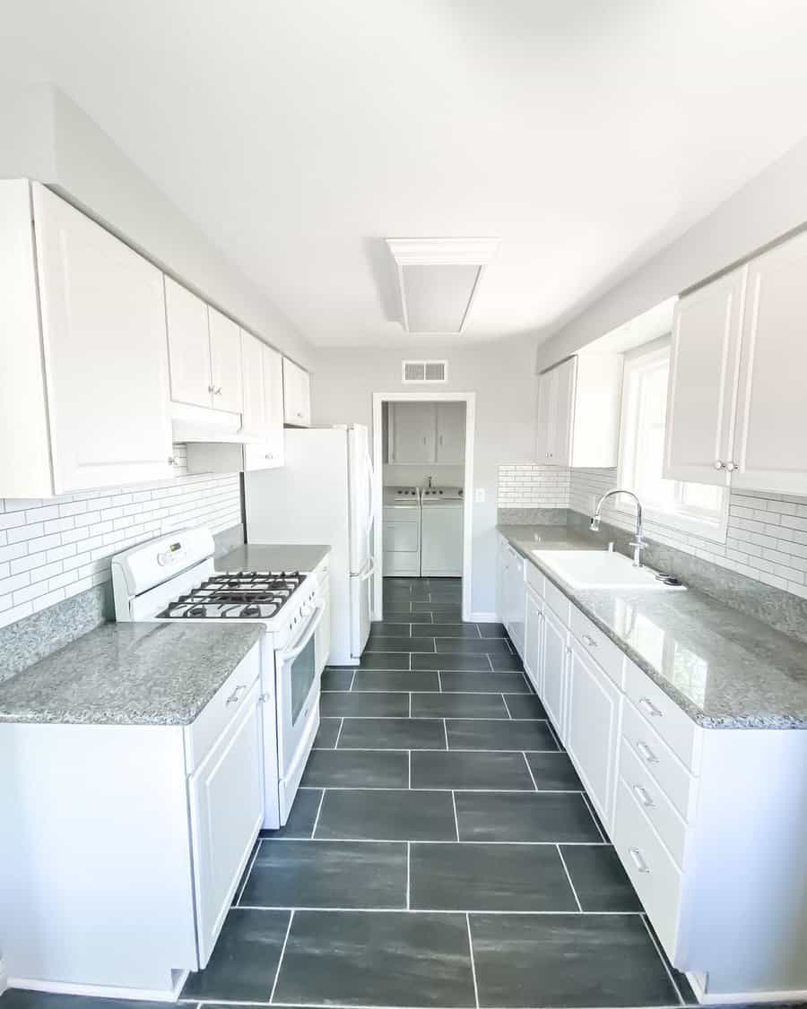 White kitchen with subway tiles and dark floor