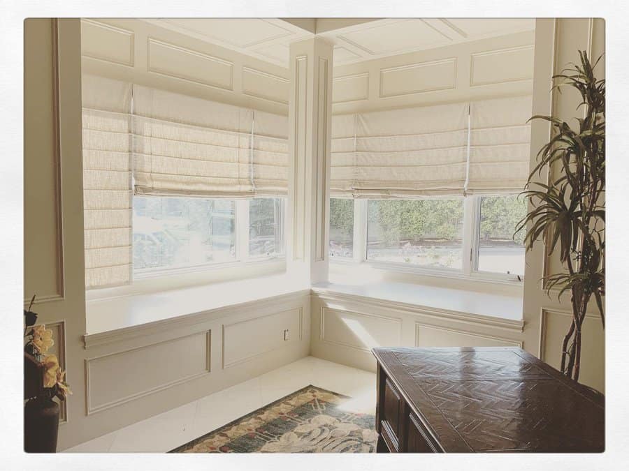 Sunlit bay area with relaxed Roman shades