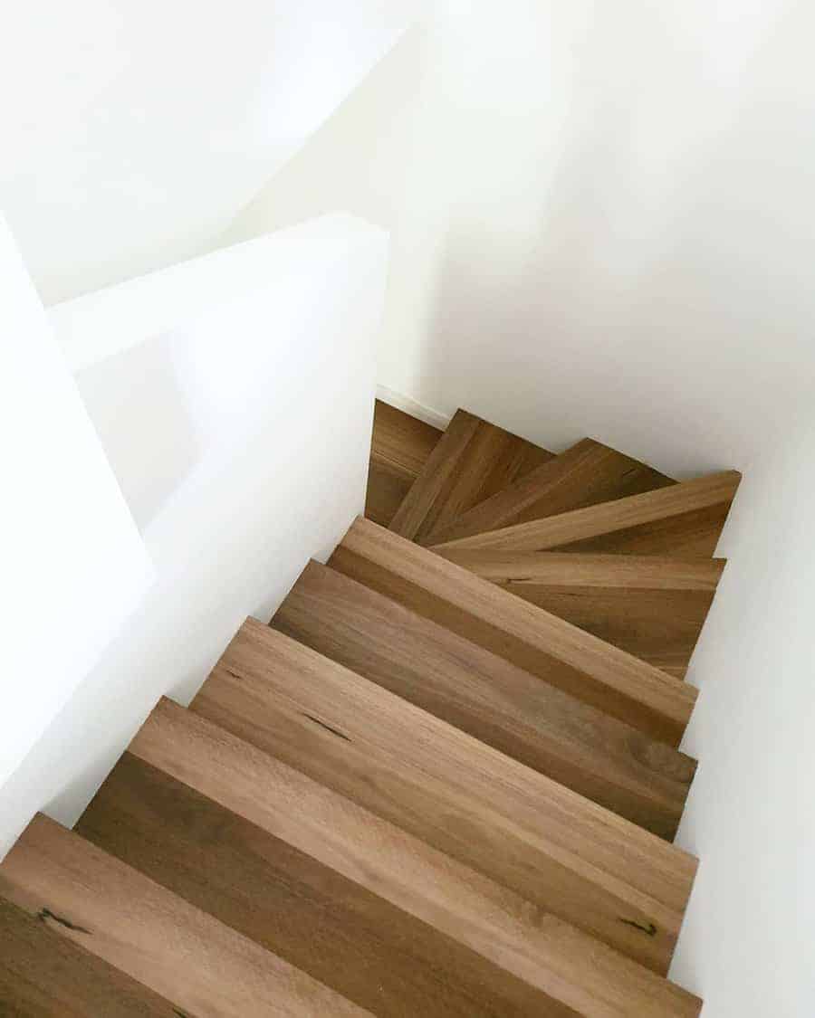 Wooden staircase with white wall backdrop