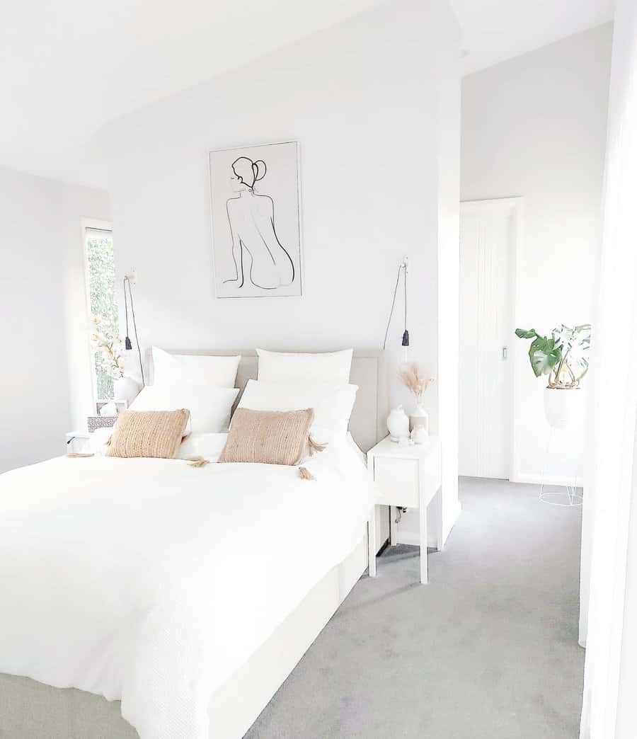 Minimalist bedroom with white bedding and line art decor