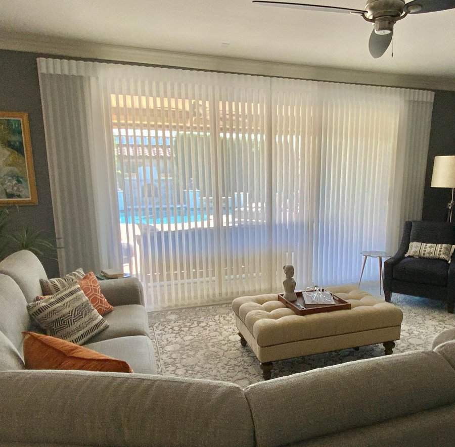 Cozy living room with sheer vertical blinds and pool view