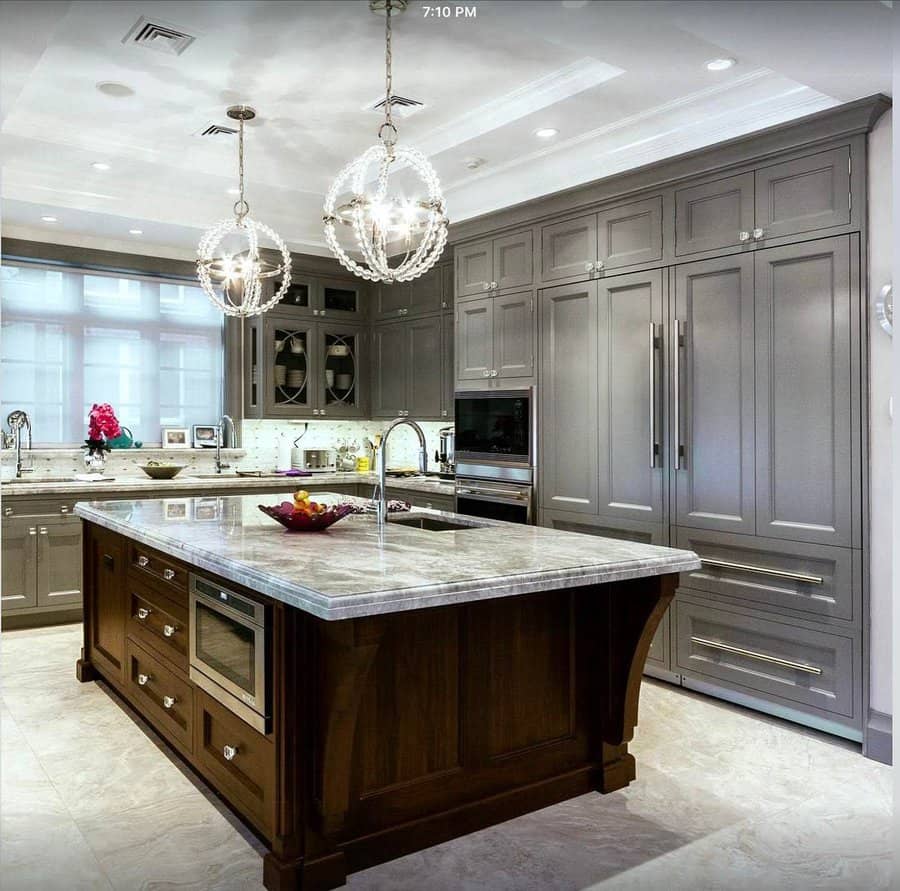 Elegant kitchen with bead chandeliers and dark wood island