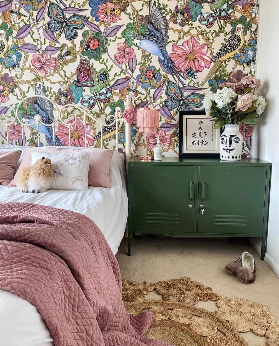 Boho bedroom with colorful floral wallpaper and green cabinet