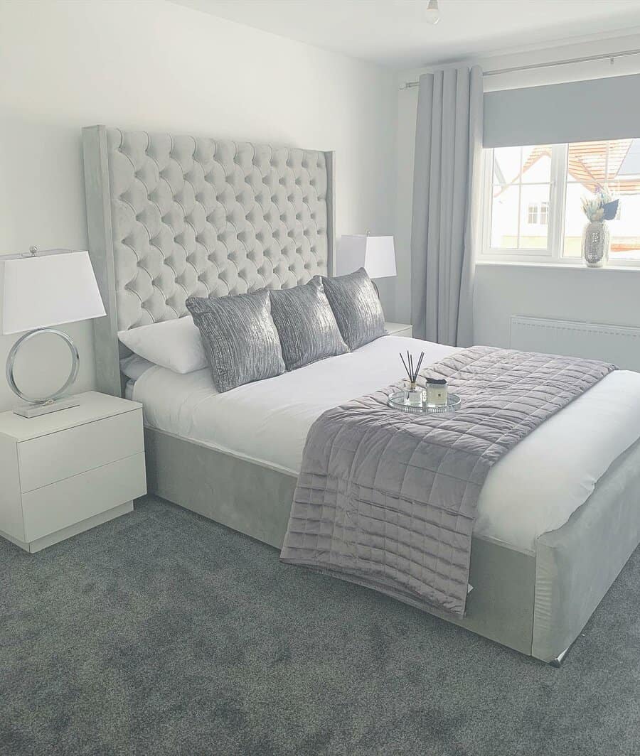 Monochromatic bedroom with plush grey textures and a large headboard