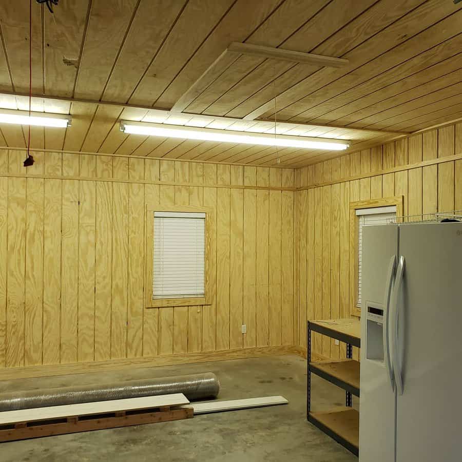 A wood garage with a fridge and windows