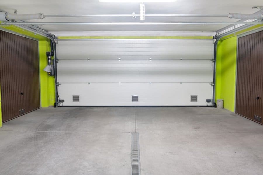 Empty garage interior with fluorescent accents and closed door
