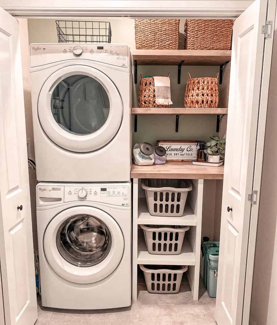 Compact laundry room featuring stacked washer and dryer, storage shelves, wicker baskets, and laundry hampers