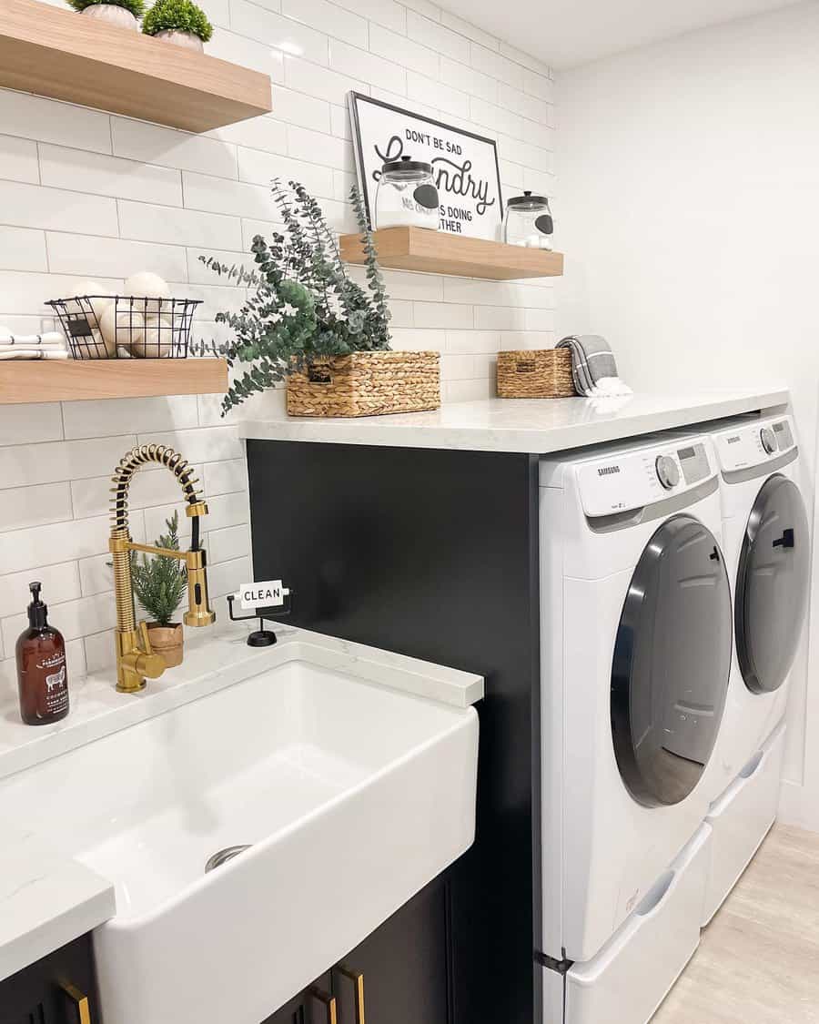 Modern laundry room with stacked washer and dryer, farmhouse sink, and wooden shelves with decor and laundry supplies