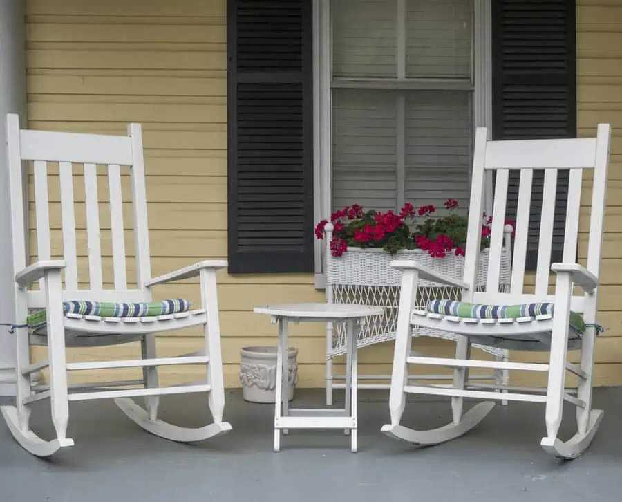 Two classic American rocking chairs on the front porch of a home.
