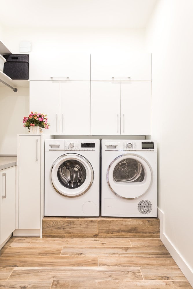 White laundry room with wall mounted cabinets