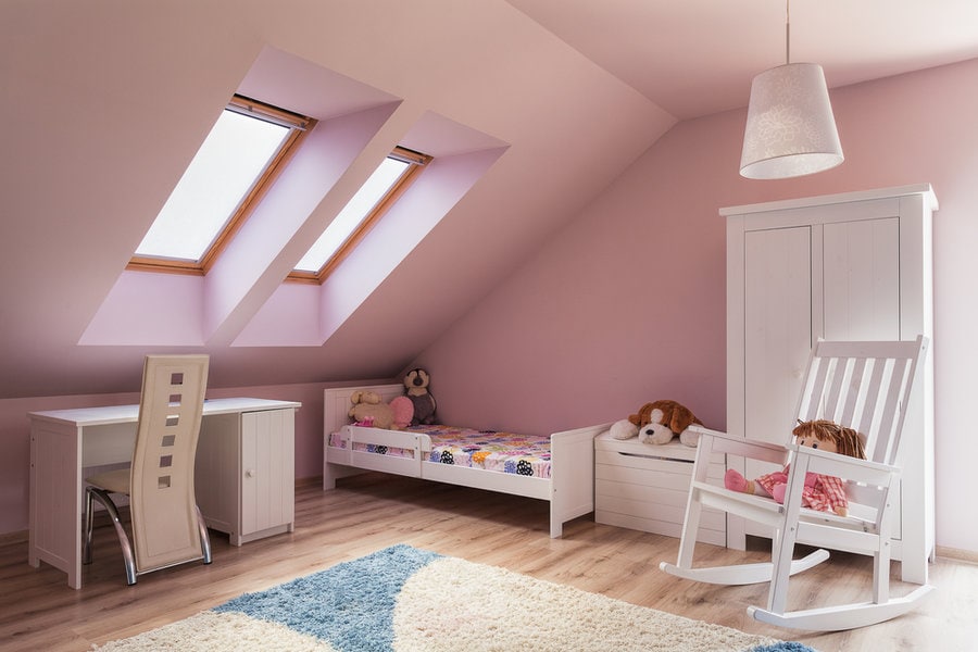 Child's attic bedroom with pink walls and skylights