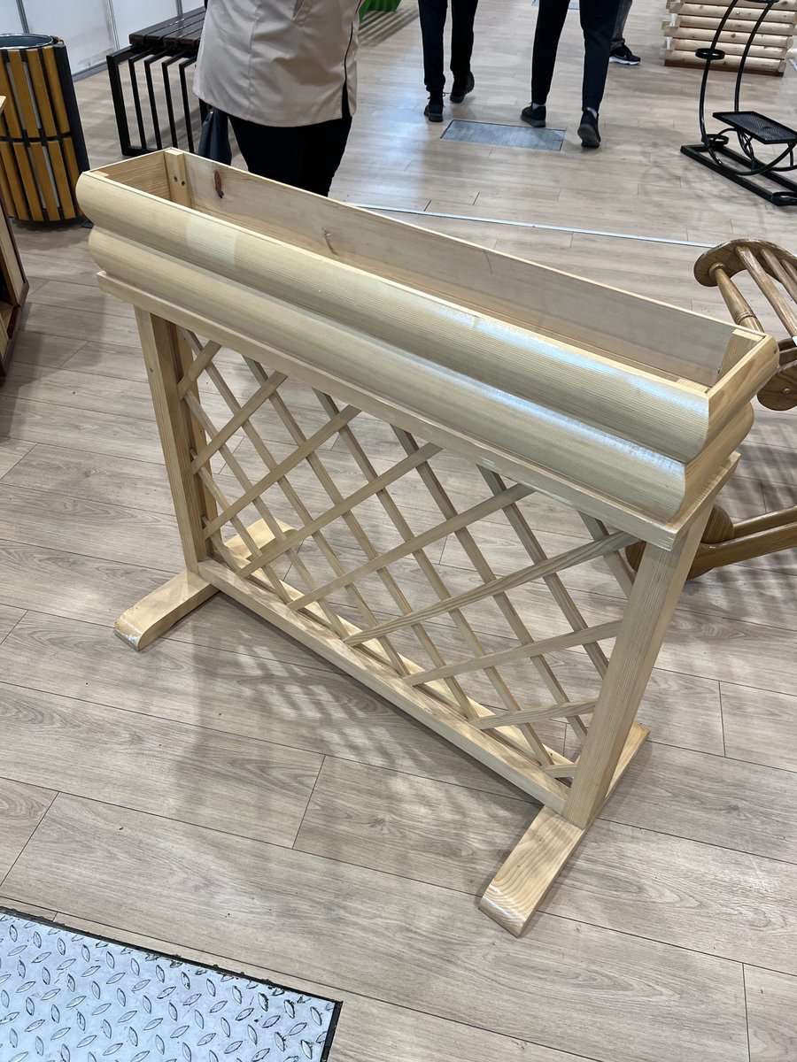 Wooden planter with a lattice design placed on a light wood floor