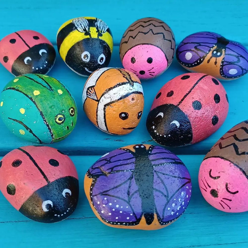 Colorful rocks painted as various insects, including ladybugs, bees, and butterflies