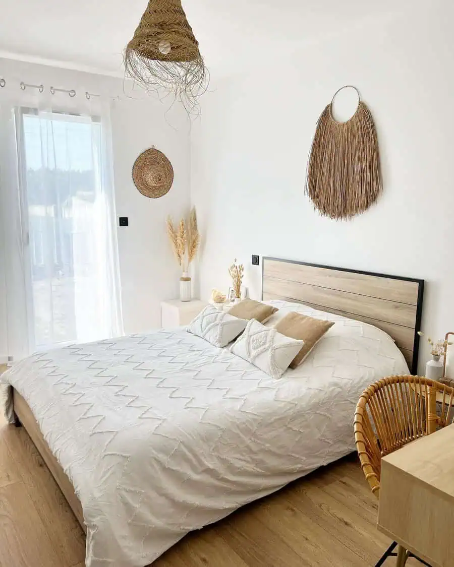 Bright bedroom with natural decor, wooden accents, wicker pendant light, and wall hangings.