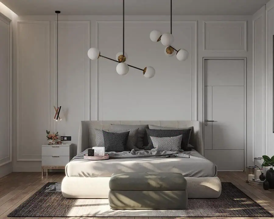 Modern bedroom with grey upholstered bed, geometric pendant lights, and minimalistic decor.