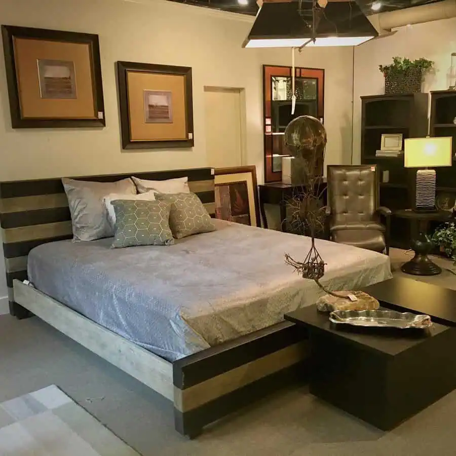 Industrial-style bedroom with a wooden platform bed, metal accents, and modern artwork.