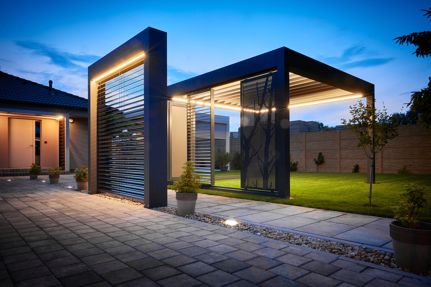 Modern outdoor patio featuring sleek geometric structures and warm evening lighting