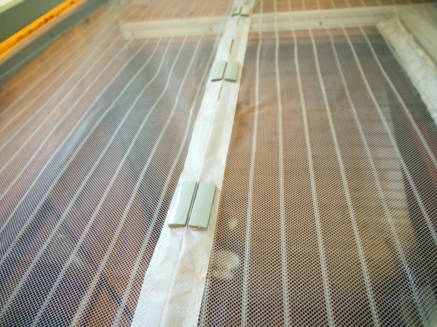 Close-up of a white mesh screen door