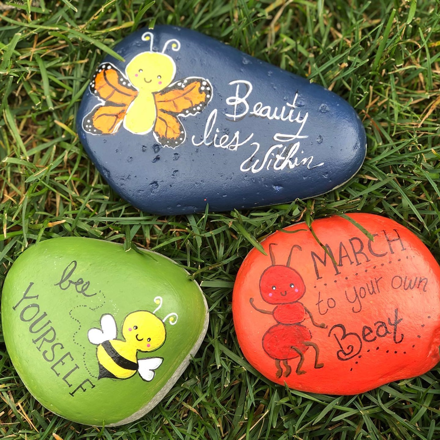 Painted rocks with messages: "Beauty lies within," "Be yourself," "March to your own beat