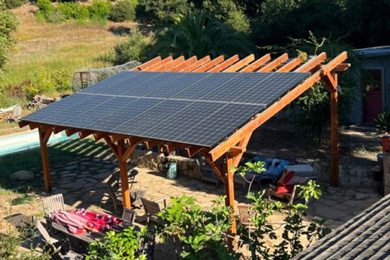 Wooden pergola with rooftop solar panels in a sunny outdoor setting