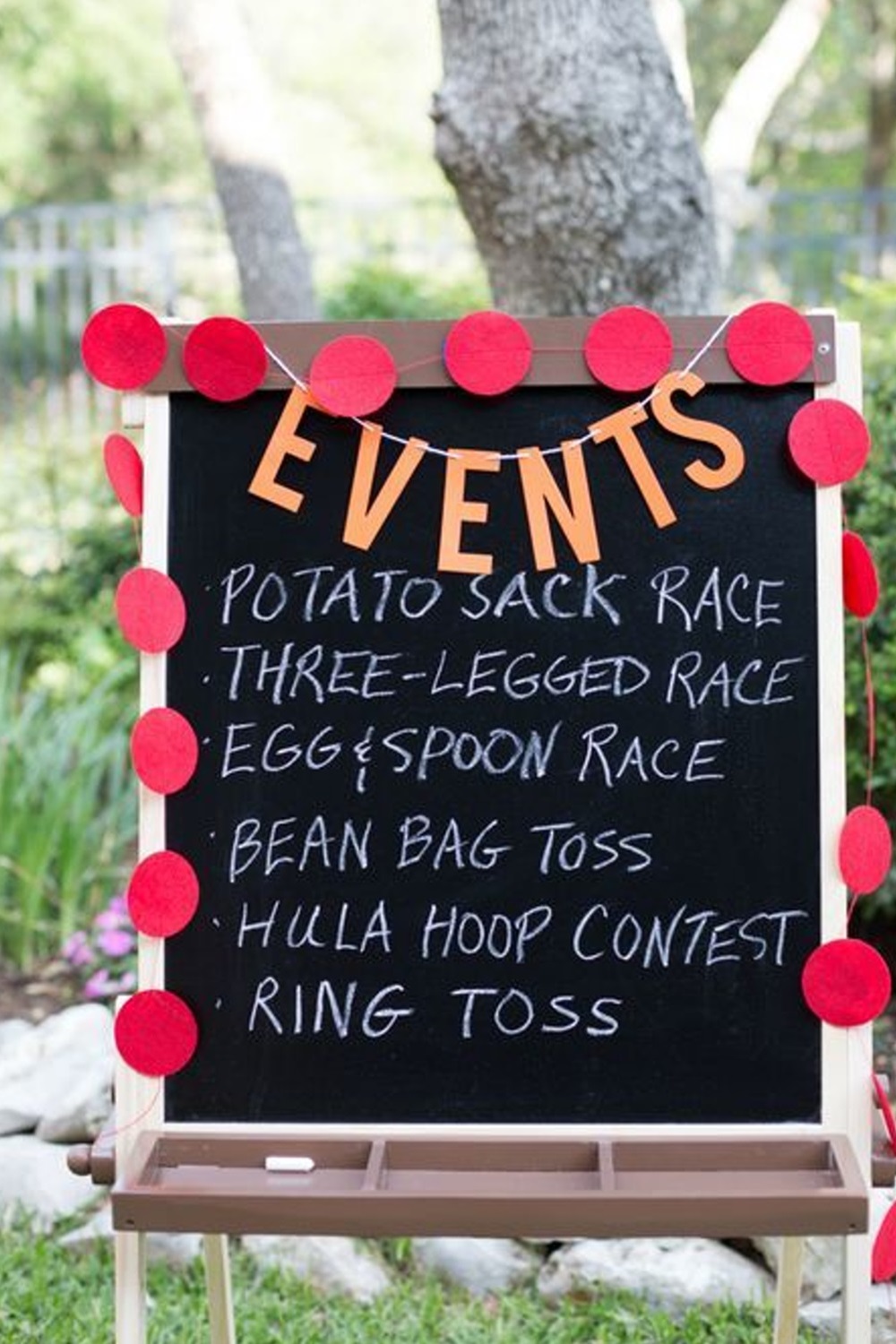 Chalkboard with outdoor events listed, decorated with red circles and "EVENTS" sign on top.