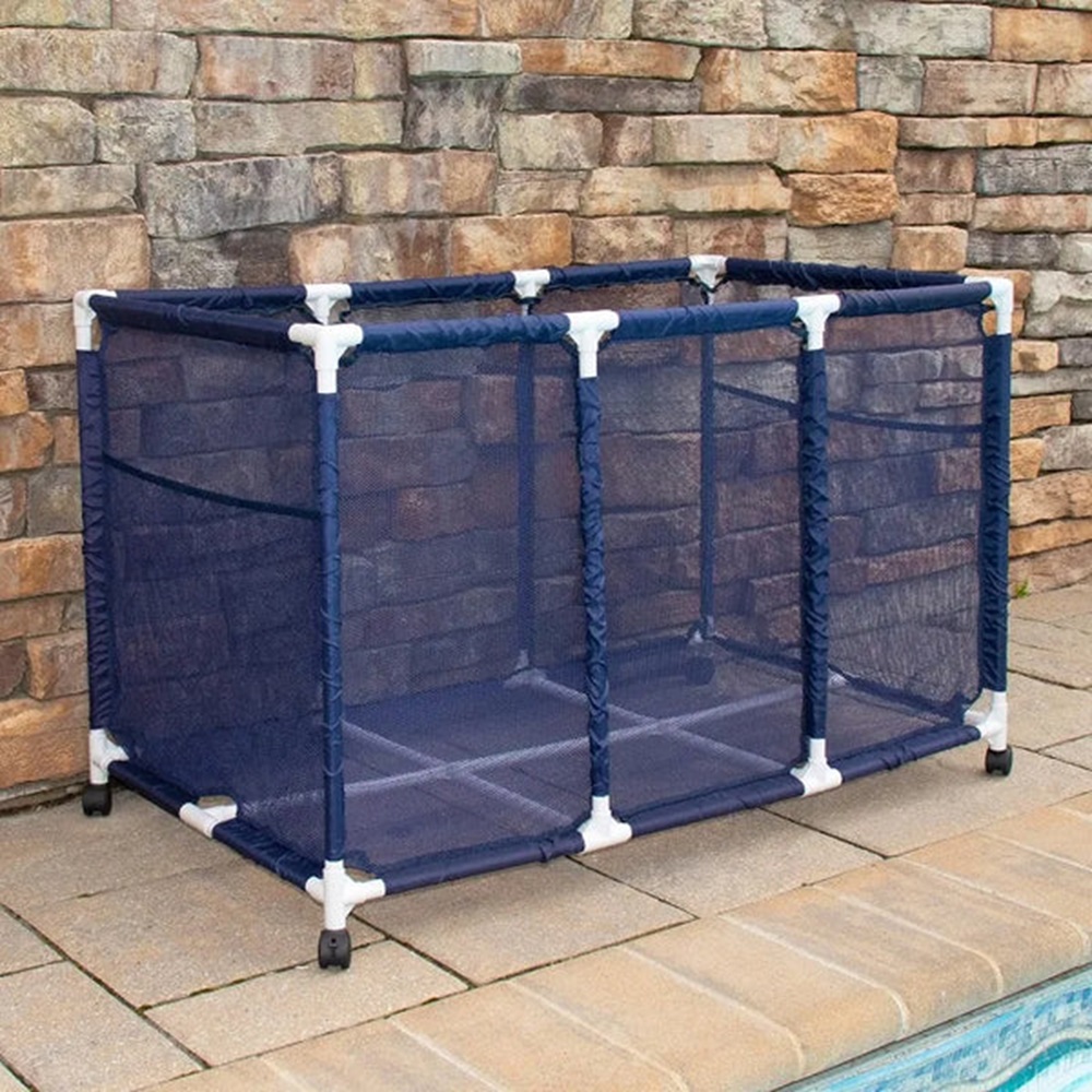 A blue mesh drying rack on wheels stands on a stone patio near a swimming pool.