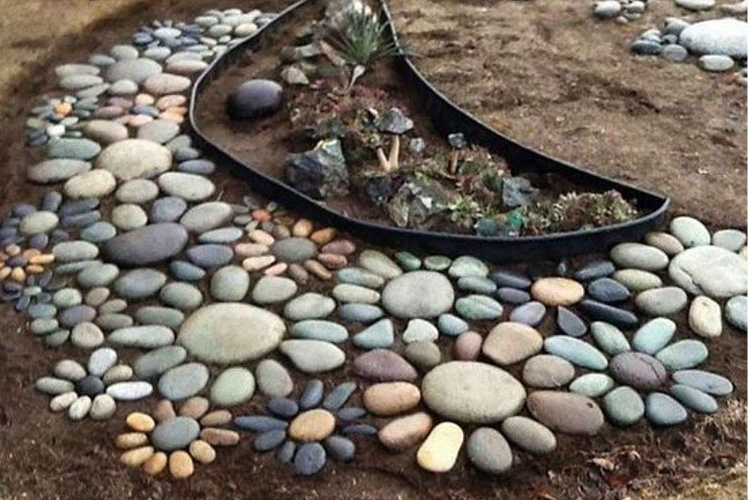 Flower shapes made from different colored stones in a rock garden