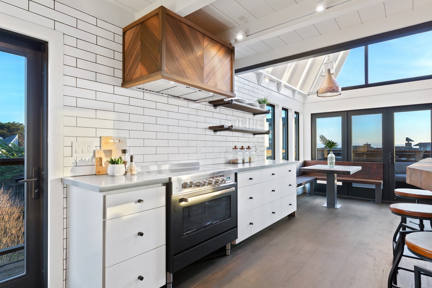 Modern kitchen featuring white cabinets, a black stove, and large windows