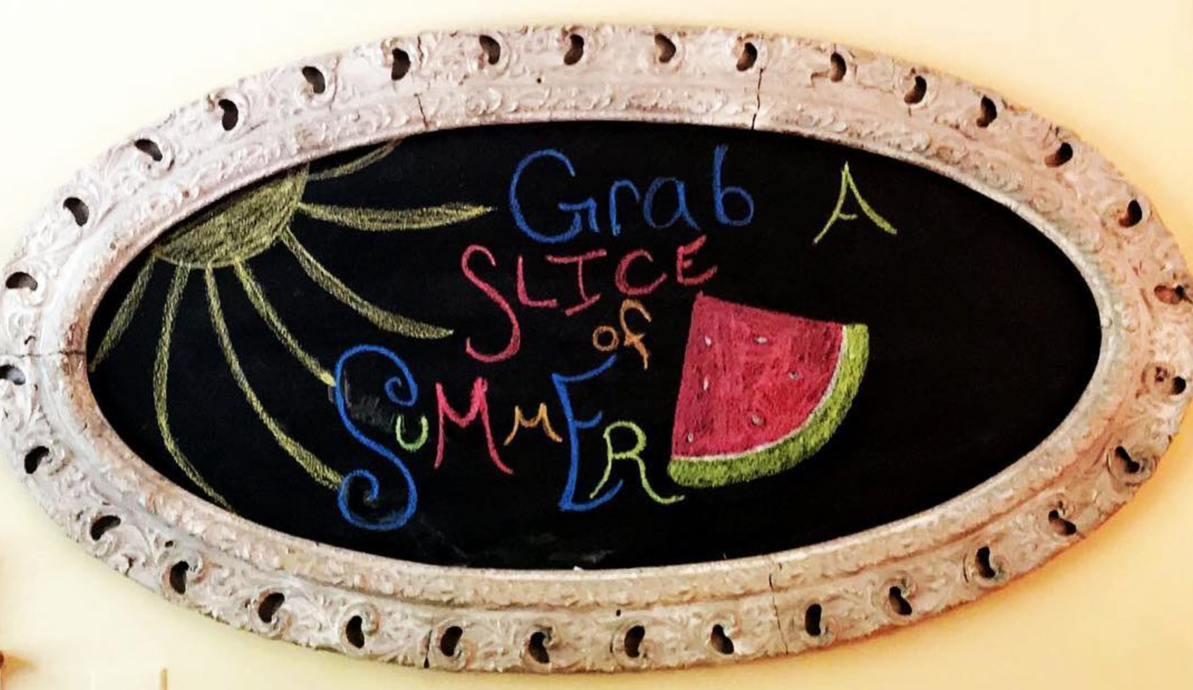 Chalkboard sign with "Grab a slice of summer" and a drawing of a sun and watermelon.