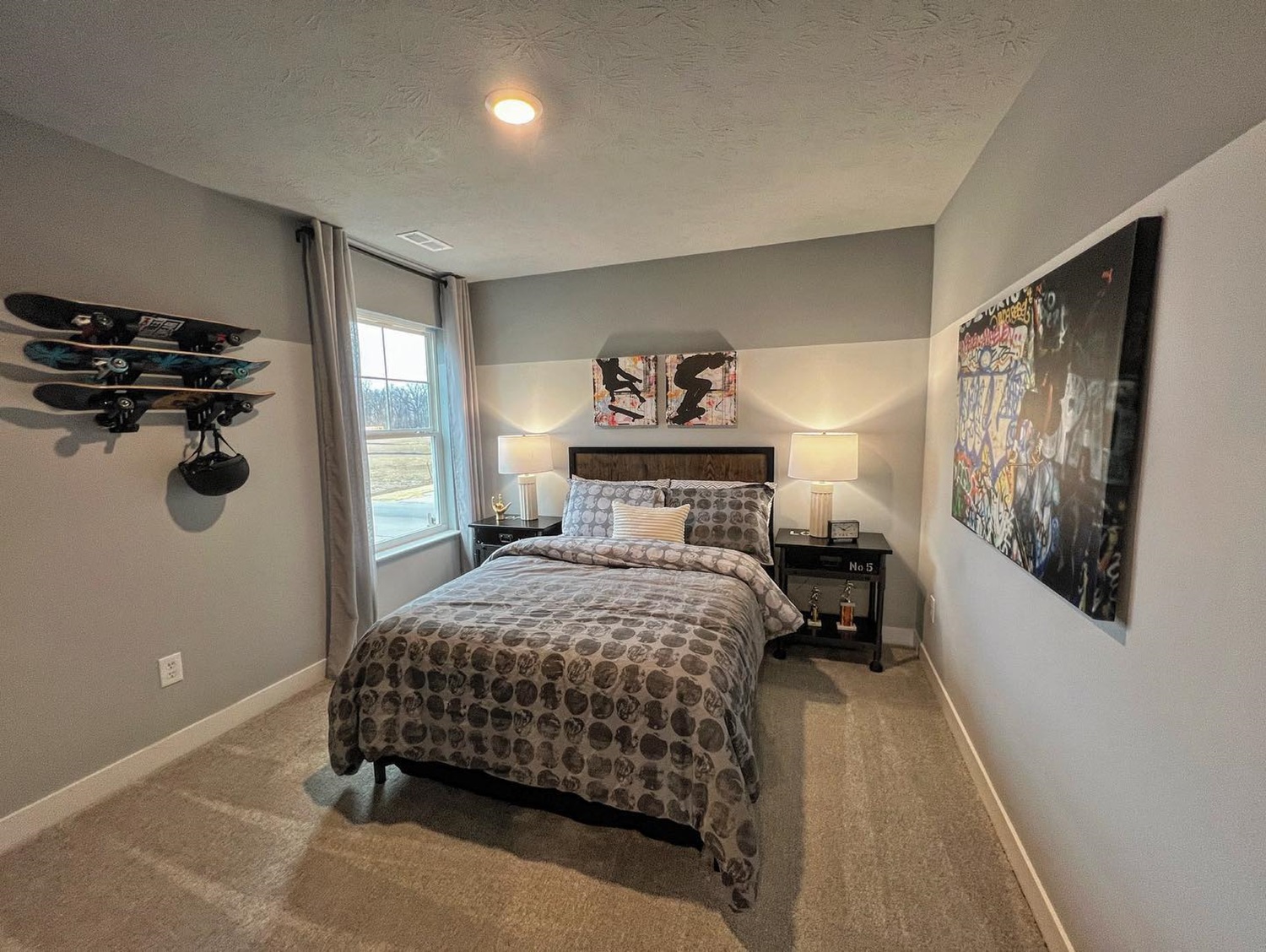 Modern bedroom with gray walls, single bed, wall art, and skateboard decor