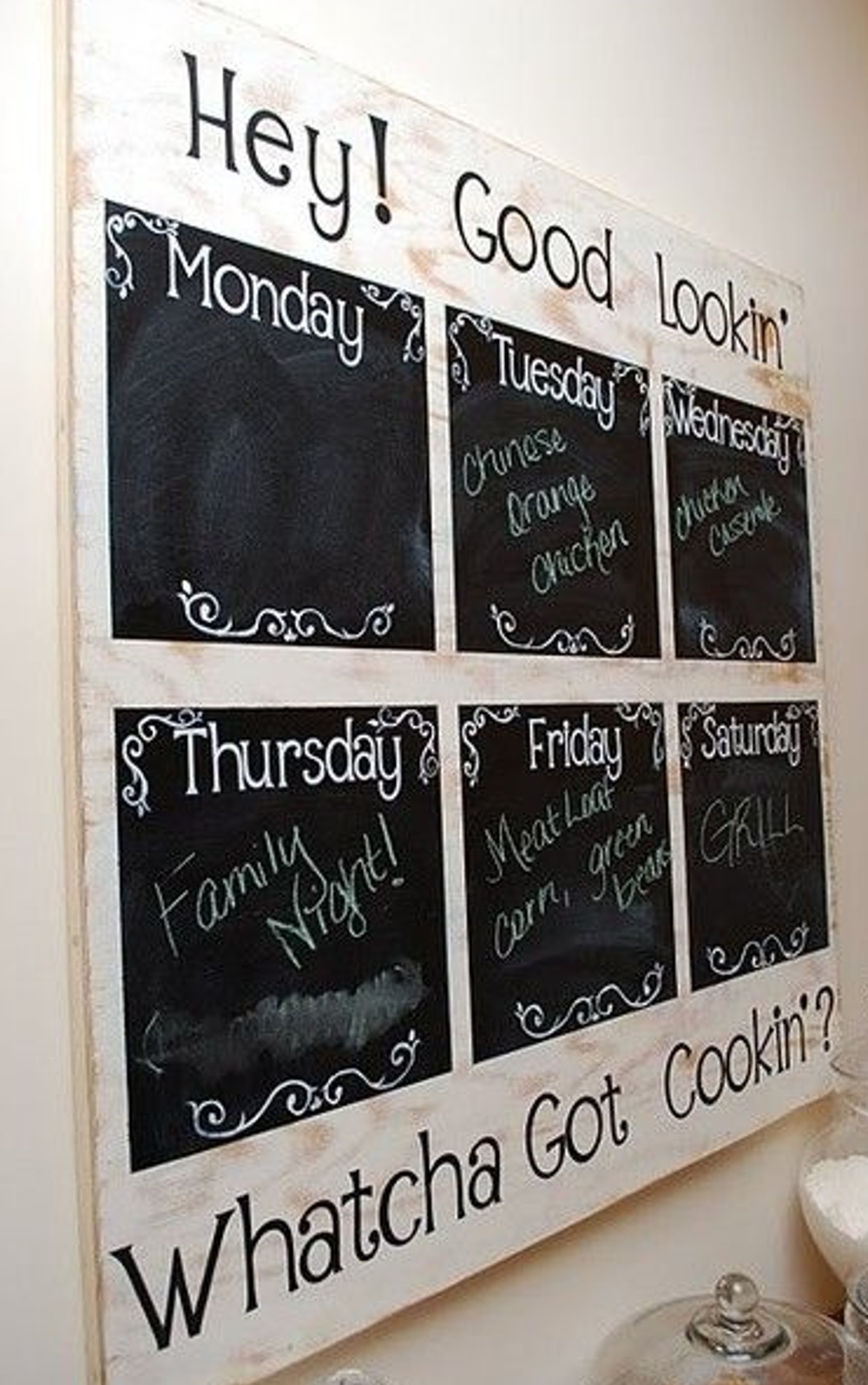 Wall-mounted weekly meal planner with days and meals written in chalk.