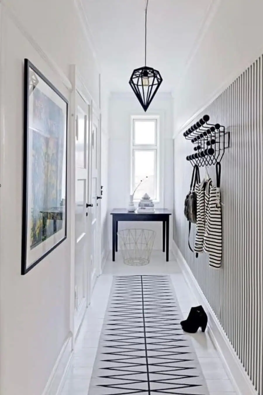 A narrow, modern entryway with a pendant light