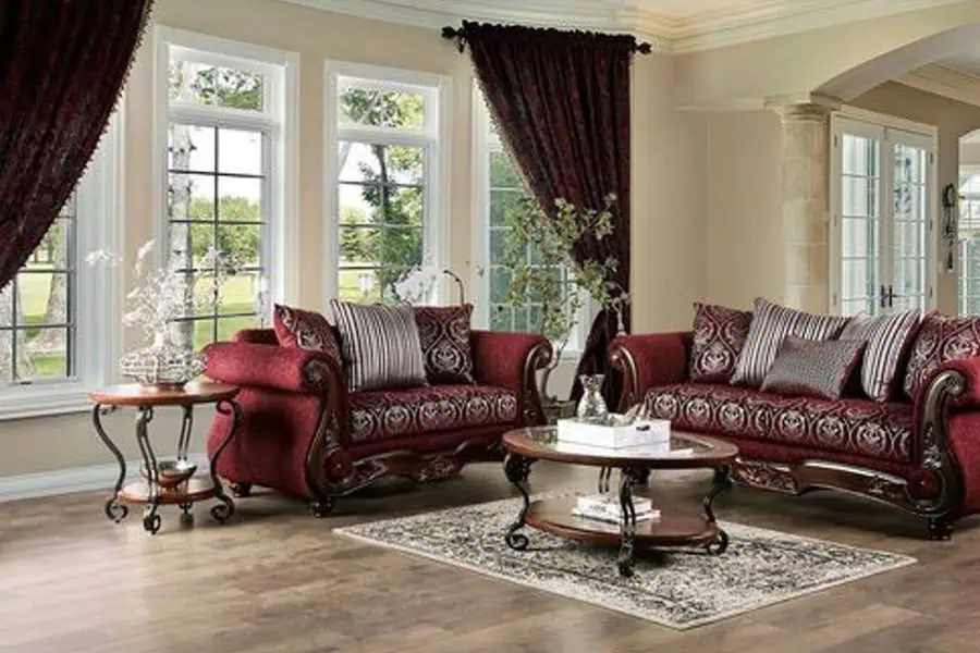 Elegant living room with burgundy upholstered furniture, large windows, and dark velvet curtains.